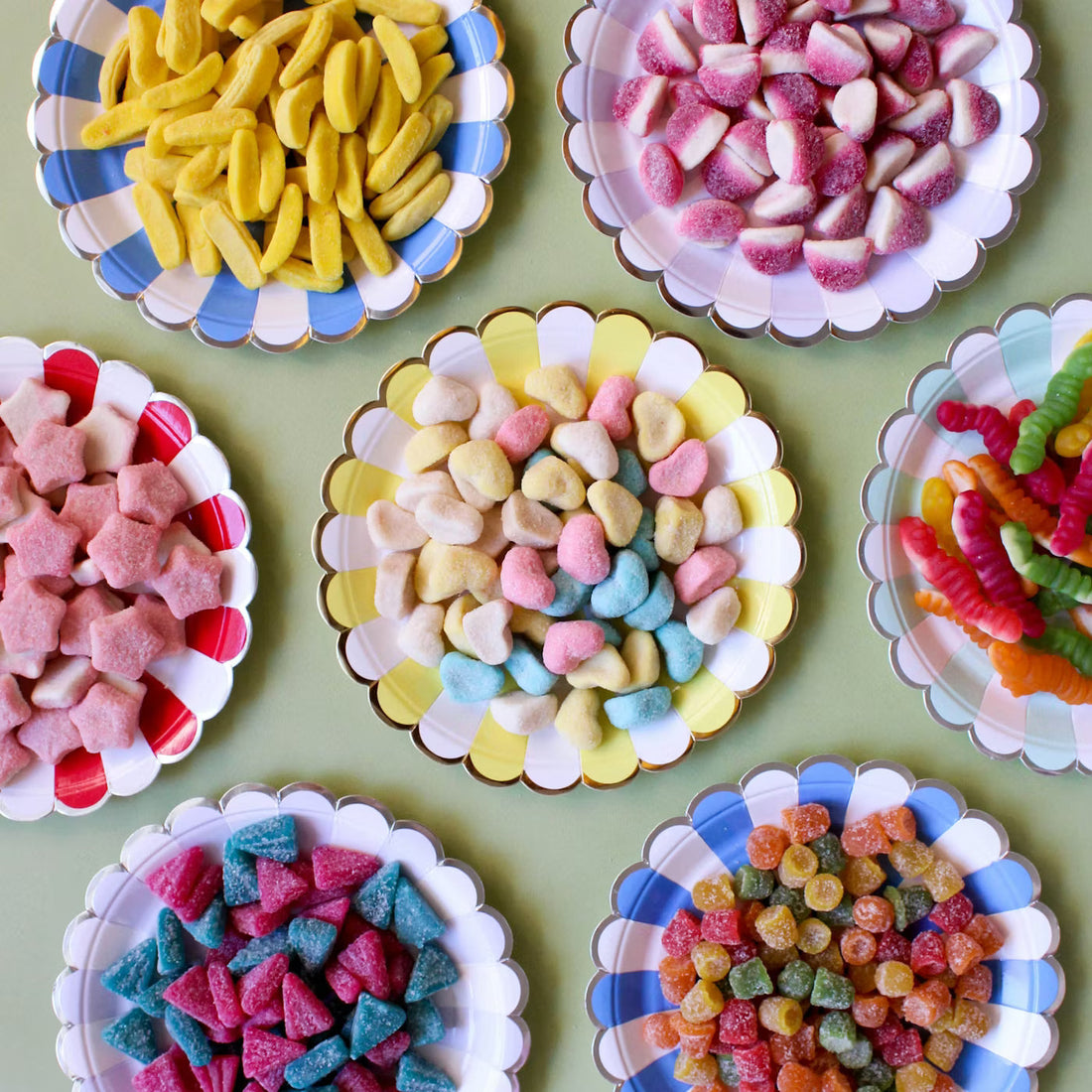 Assortiment de bonbons à l'unité présentés dans des assiettes colorées pour un anniversaire - Sweet Land