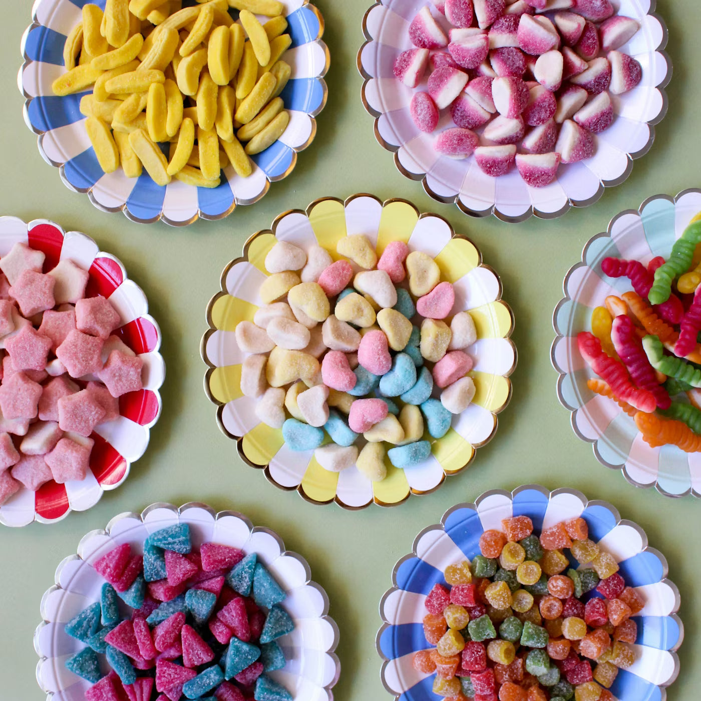 Assortiment de bonbons à l'unité présentés dans des assiettes colorées pour un anniversaire - Sweet Land