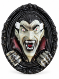 Décoration murale Halloween représentant un vampire Dracula en relief dans un cadre ovale noir sur fond blanc