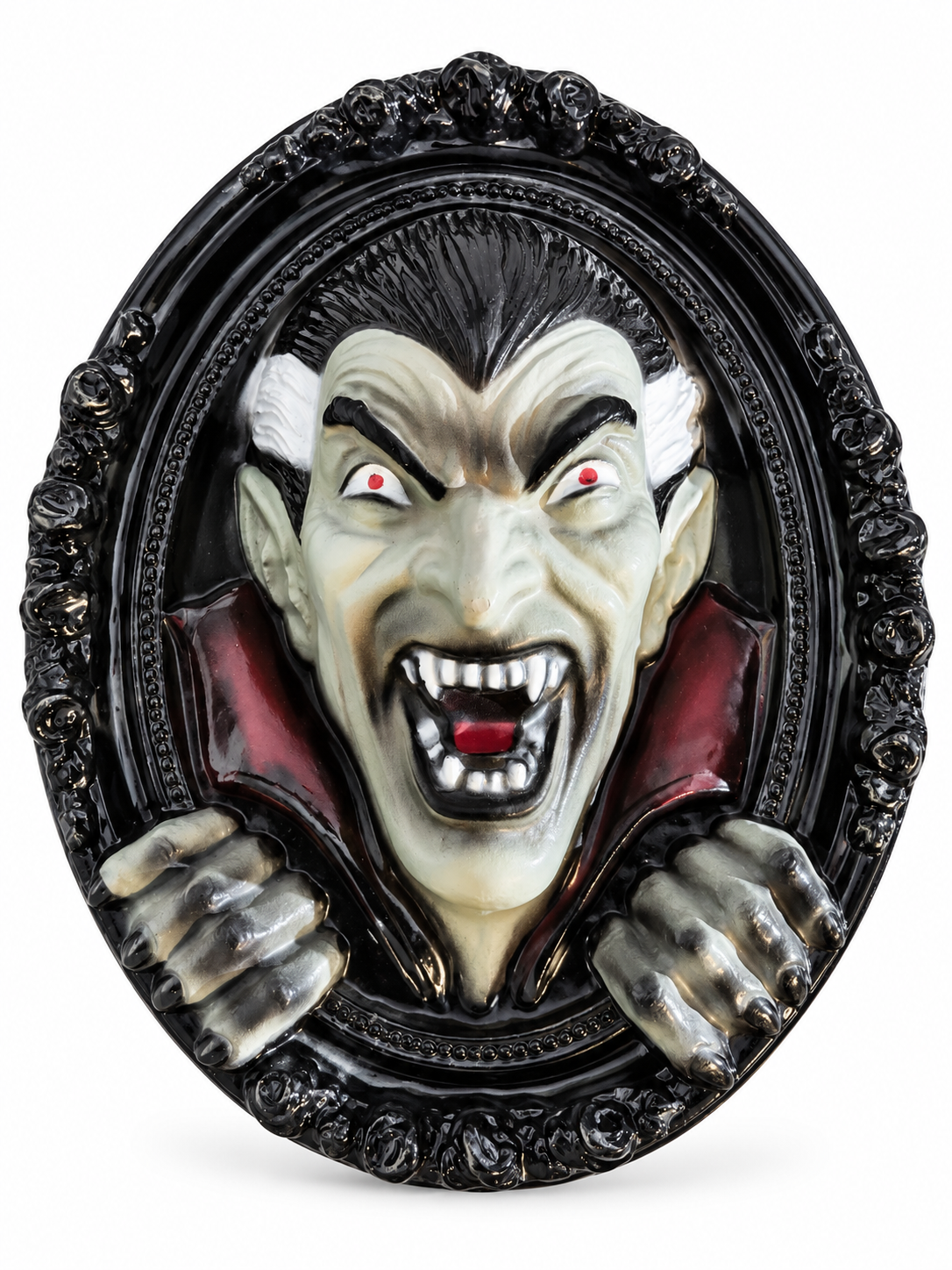 Décoration murale Halloween représentant un vampire Dracula en relief dans un cadre ovale noir sur fond blanc