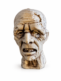 Tête de zombie décorative pâle au visage ridé et fissuré sur fond blanc